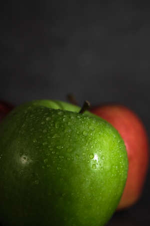 green and red apple on dark backgroundの写真素材
