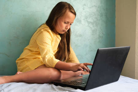 Little girl learns from a laptop computerの写真素材