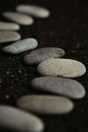 small sea pebbles are laid out on a black backgroundの写真素材