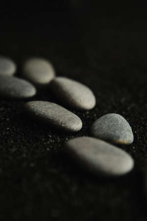 small sea pebbles are laid out on a black backgroundの写真素材