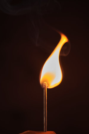 a lighted match on a dark backgroundの写真素材