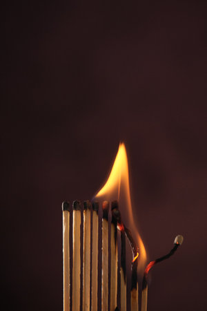 a row of matches are lit on a dark background