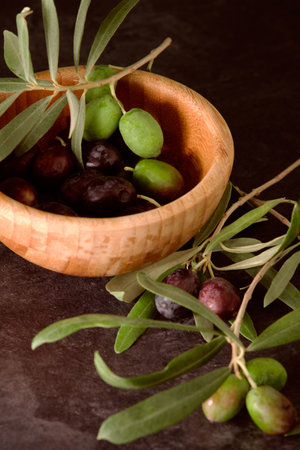 a wooden bowl with olivesの写真素材
