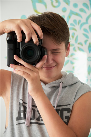 a boy with camera in his handsの写真素材