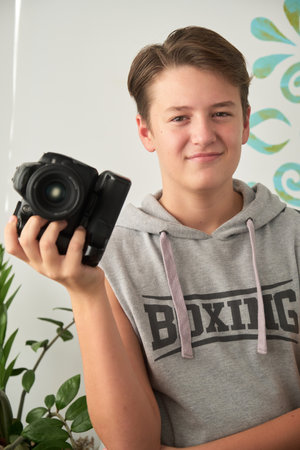 a boy with camera in his handsの写真素材
