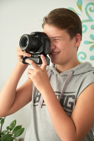 a boy with camera in his handsの写真素材