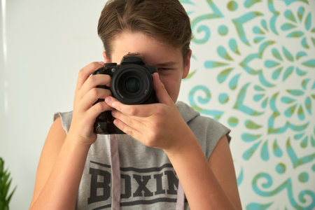 a boy with camera in his handsの写真素材