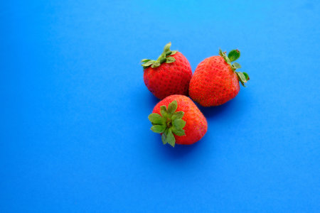red ripe strawberries on a blue backgroundの写真素材