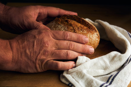 black round bread in the hands of a man in the style of rustic