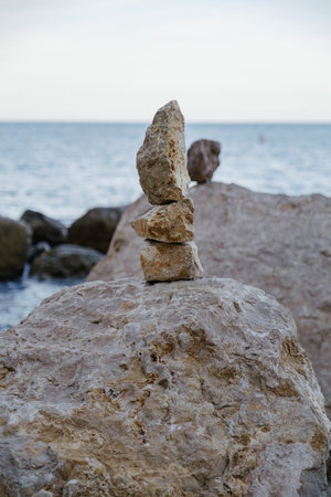On the beach there are pyramids of stones made by manの写真素材