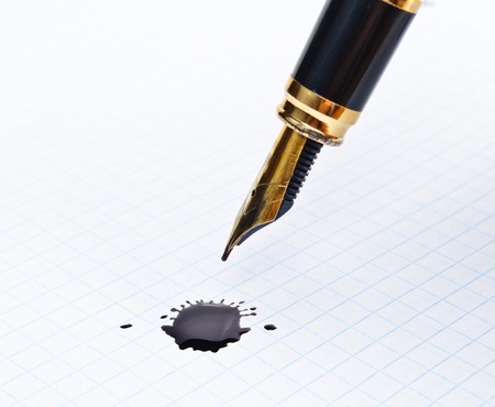 Ink pen and a notebook on the blot. Close-up Photosの写真素材