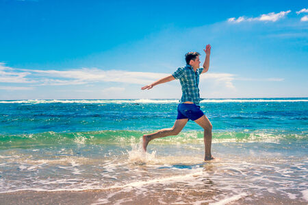 Young man enjoying freedom on the ocean. Summer holiday and vacation conceptの写真素材