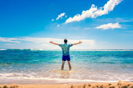 Raising hands. Travel and Vacation concept. Happy young man outdoors. Joyful man. Summer. Holidaysの写真素材