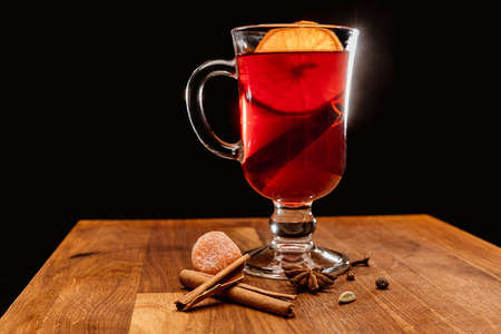 Glass of mulled wine with a slice of lemon on a dark backgroundの写真素材