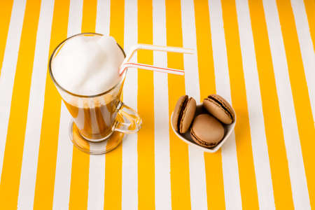 Irish Cup of coffee with milk and macaroni cake on a striped background.の写真素材