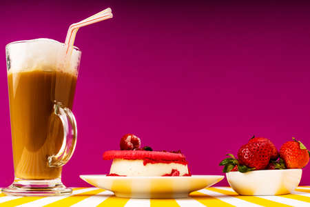 Irish Cup of coffee with milk, raspberry cake, fresh sweet strawberries on a purple background.の写真素材