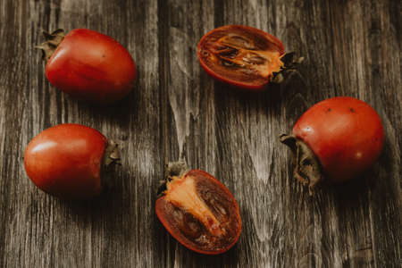 persimmon on a wooden table on a dark backgroundの写真素材