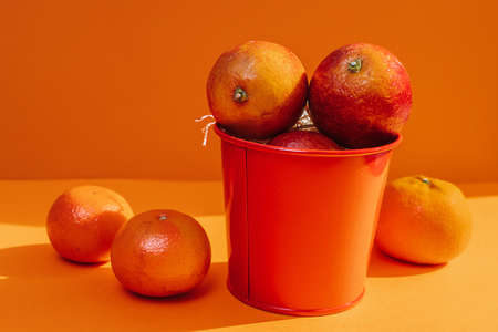 oranges in a bucket on a colored backgroundの写真素材