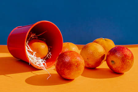 oranges in a bucket on a colored backgroundの写真素材