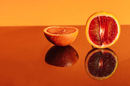 oranges and orange slices on a colored background with a place for the textの写真素材