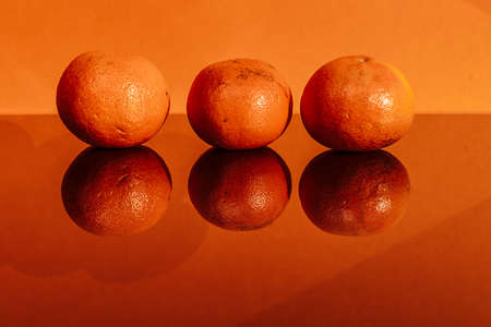 oranges and orange slices on a colored background with a place for the textの写真素材