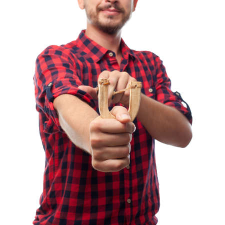 Young man over white background using a wooden slingshotの写真素材