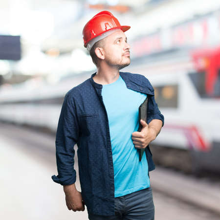 Young man wearing a blue outfit. Wearing red helmet. Looking to the side