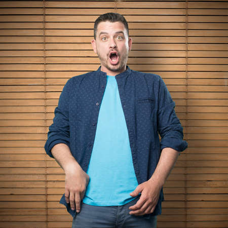 Young man wearing a blue outfit. Looking surprised.の写真素材