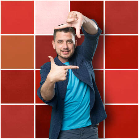 Young man wearing a blue outfit. Doing frame shape.の写真素材