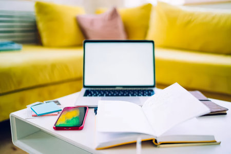 Closeup of laptop, smartphone and notebook on the table at home
