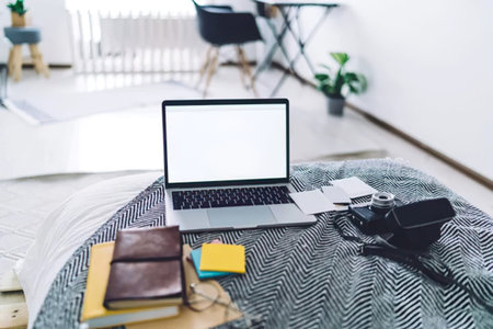 laptop with blank screen on bedside table in bedroom at home