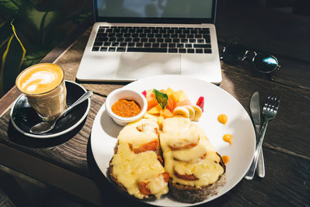 Breakfast in a cafe with a laptop and a cup of coffee