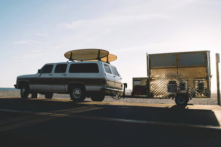 Camper van with luggage on the beach at sunset. Vacation and travel concept.