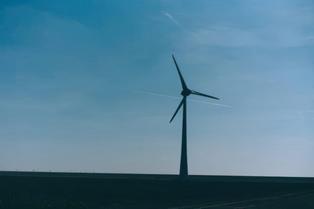 An image of windturbine generator in the field at sunset