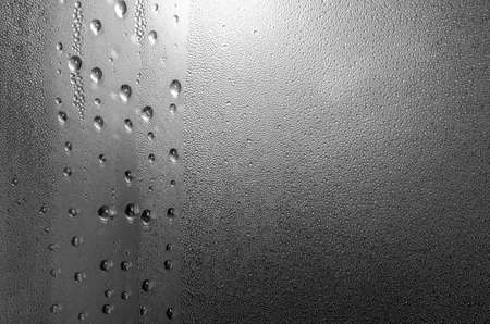 Raindrops on a window glass in the eveningの写真素材