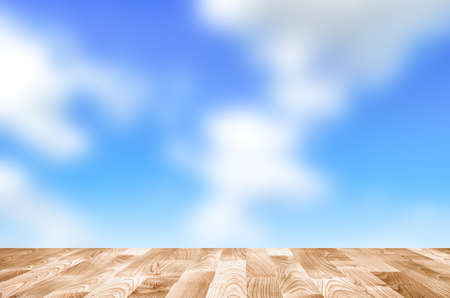 Empty wooden table with blue sky bokeh