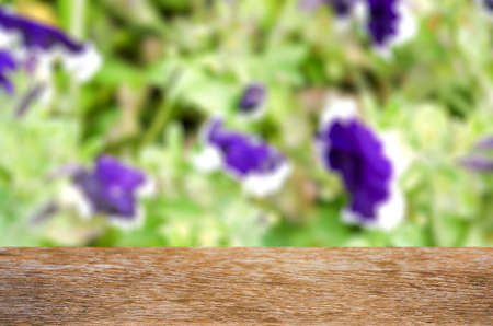 Empty wooden table with garden bokeh for a catering or food background