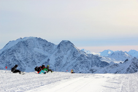 snowboarders sit on snow on the slopes of Mountain Elbrus Caucasusの写真素材