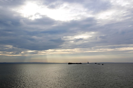 sunset over the sea, small islands and the ship sailing awayの写真素材