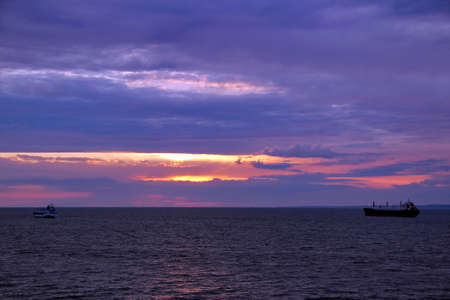 sunset over the sea and the ships sailing awayの写真素材