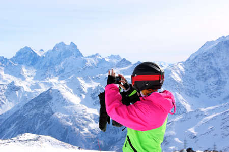 girl in a colorful suit photographed on top of a snowy mountainの写真素材