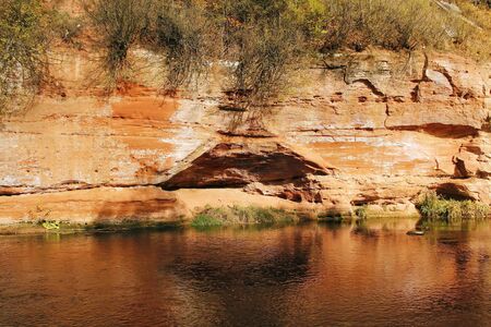 autumn trees on a sandy above a small riverの写真素材