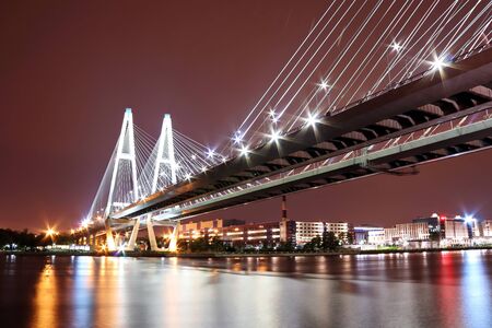 cable-stayed bridge over the river at night with colorful bright lightingの写真素材