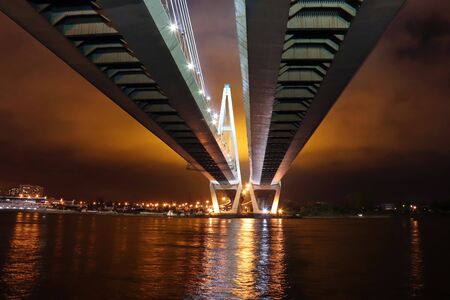 cable-stayed bridge over the river at night with colorful bright lightingの写真素材