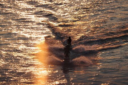 two water scooter float on the water at sunsetの写真素材