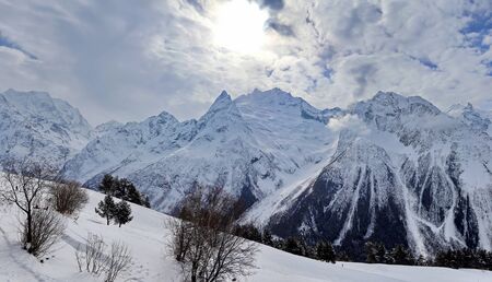 Panoramic view of snowy mountains peaks in the clouds blue sky Caucasusの写真素材