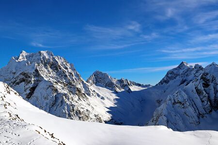 Snowy Mountains peaks in the clouds blue sky Caucasusの写真素材