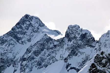 Snowy Mountains peaks in the clouds blue sky Caucasusの写真素材