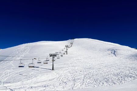 skilift in the snowy mountains and deep blue skyの写真素材
