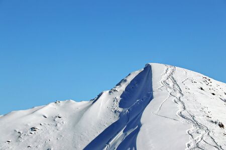 Snowy Mountains peak and clear blue skyの写真素材